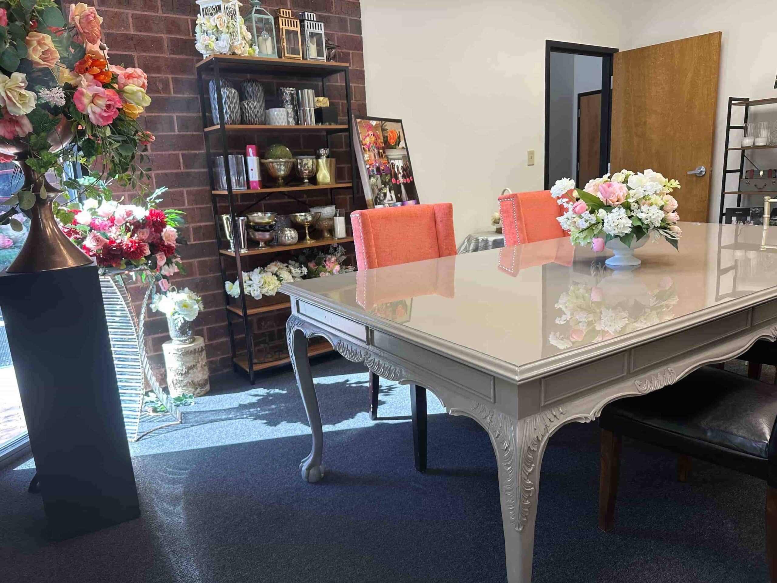 Flowers By Impressions Suwanee office with a floral centerpiece on the table and decorative items displayed on shelves in the background