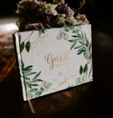 Guest book decorated with greenery and florals, perfect for a Fall wedding reception.