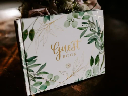 Guest book decorated with greenery and florals, perfect for a Fall wedding reception.