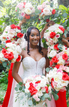 Bride holding a stunning bride bouquet surrounded by vibrant floral arrangements.