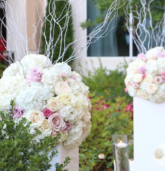 Tall floral pedestal with hydrangeas, blush pink, and cream roses for a wedding ceremony at Villa Christina in Atlanta.