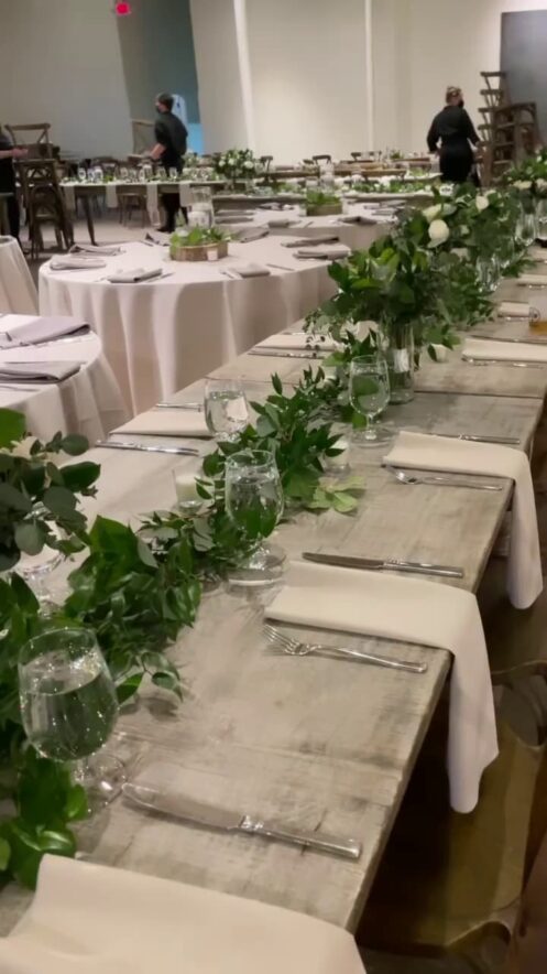 Elegant wedding reception table featuring a lush greenery table runner and white napkins at The Stave Room, Atlanta.