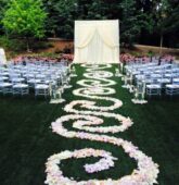 Outdoor wedding ceremony aisle at Villa Christina in Atlanta decorated with blush pink and white rose petals.