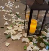 Elegant wedding aisle lantern surrounded by white rose petals and greenery, creating a romantic ambiance at The Stave Room in Atlanta.