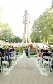 Outdoor wedding ceremony with floral aisle decorations and large flower arrangements.