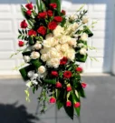A striking floral arrangement by Buford Sympathy Flower Florist featuring a mix of red roses and white roses with lush green leaves