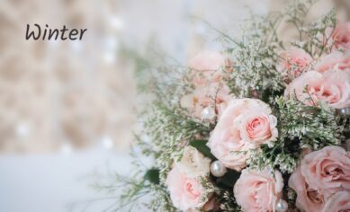 Winter flower bouquet with pale pink roses and white greenery.